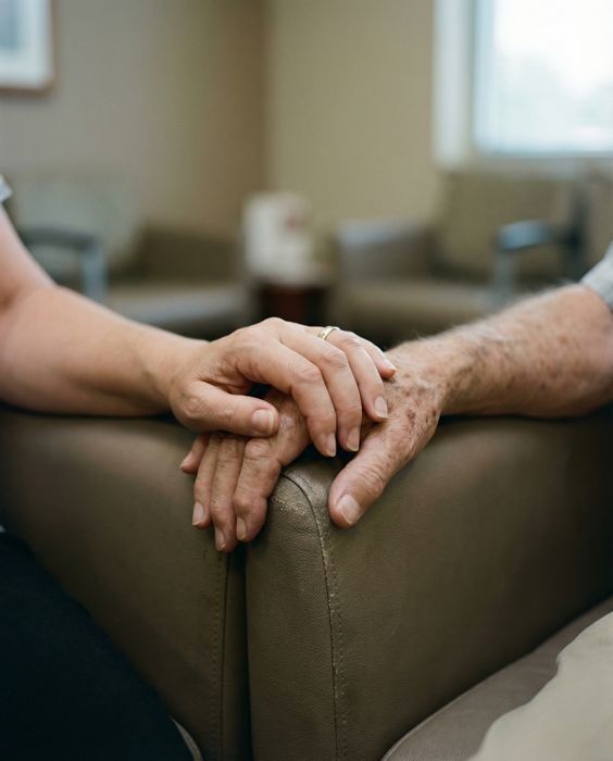 A younger hand resting on an older parent’s hand
