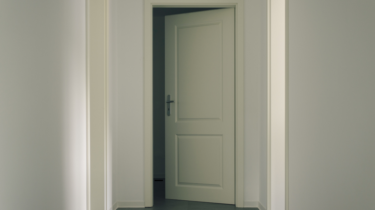 Partially opened door into a dark room