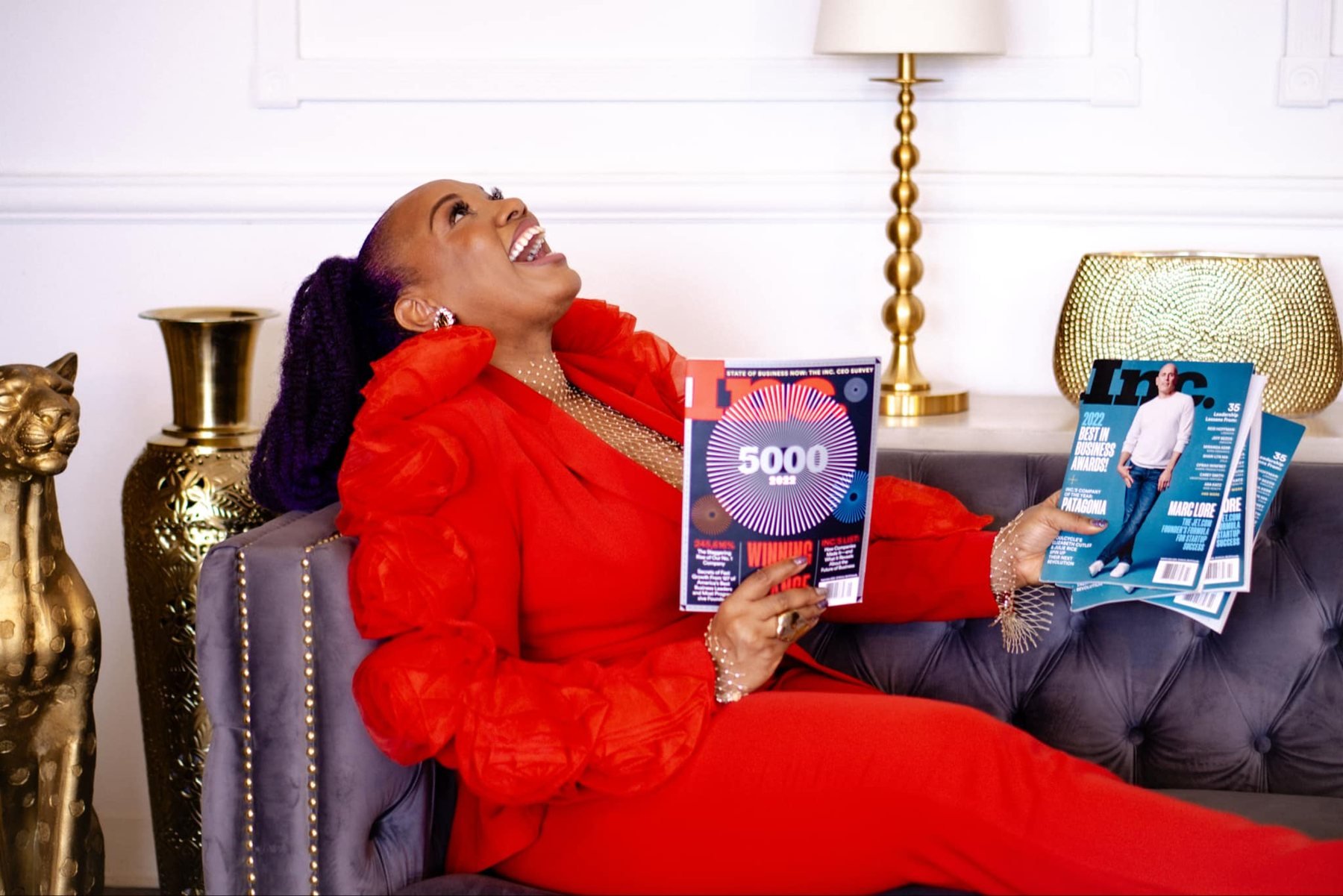 Shameca laughing on a sofa holding Inc. magazines