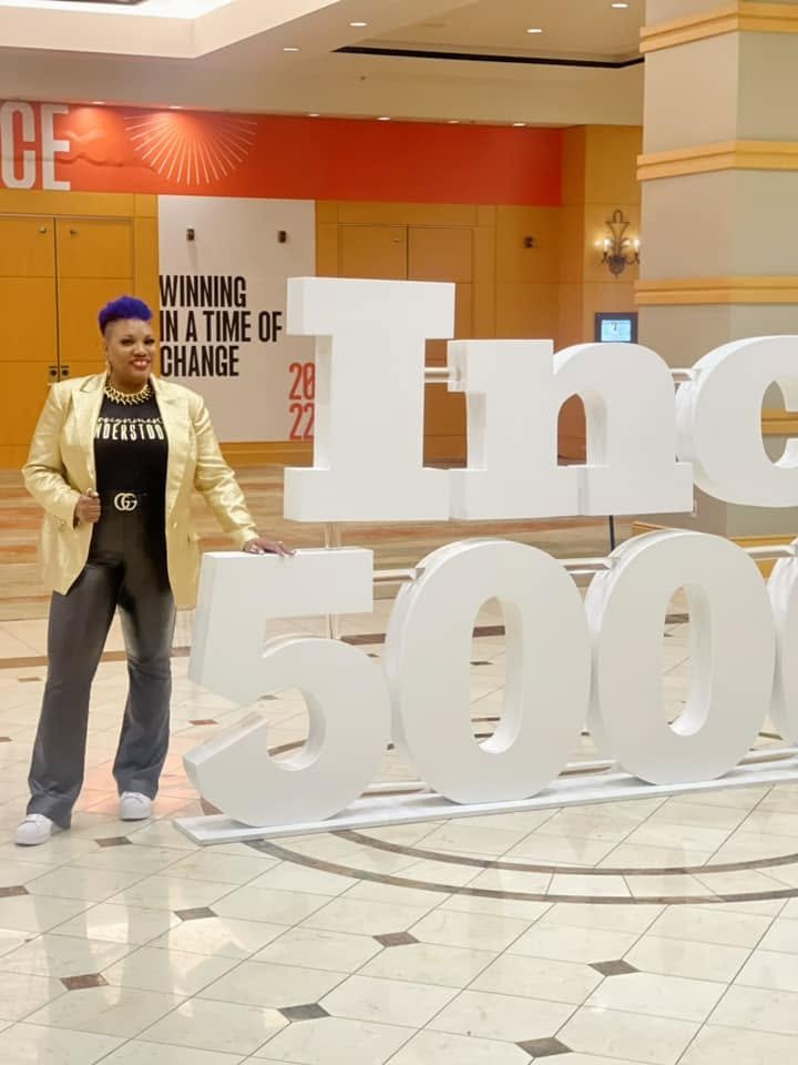 Shameca at the Inc. 5000 gala beside the Inc. 5000 sign