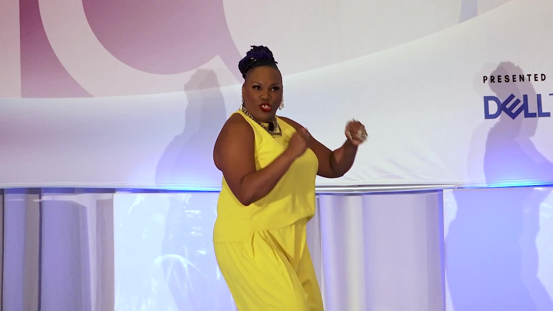 Shameca crouching on stage as she tells her skydiving story