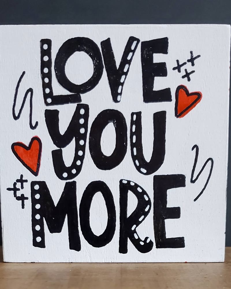 Hand lettered 'Love You More' sign, made by a student