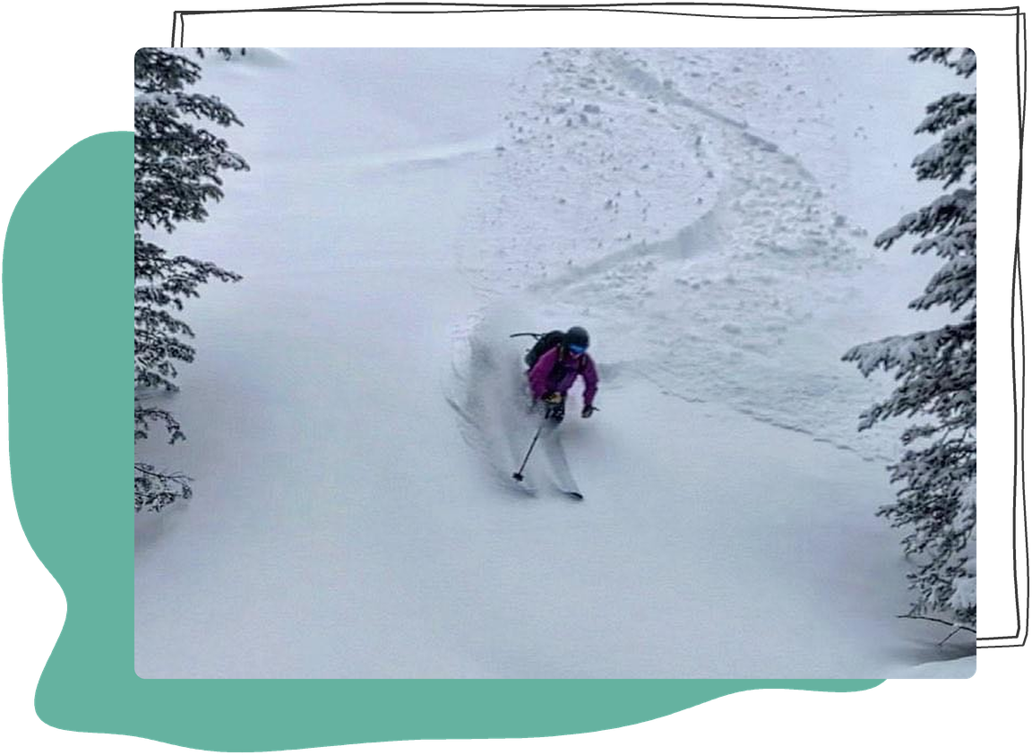 Elise P., Everyday Self-Compassion student, skiing through fresh powder between snowy trees