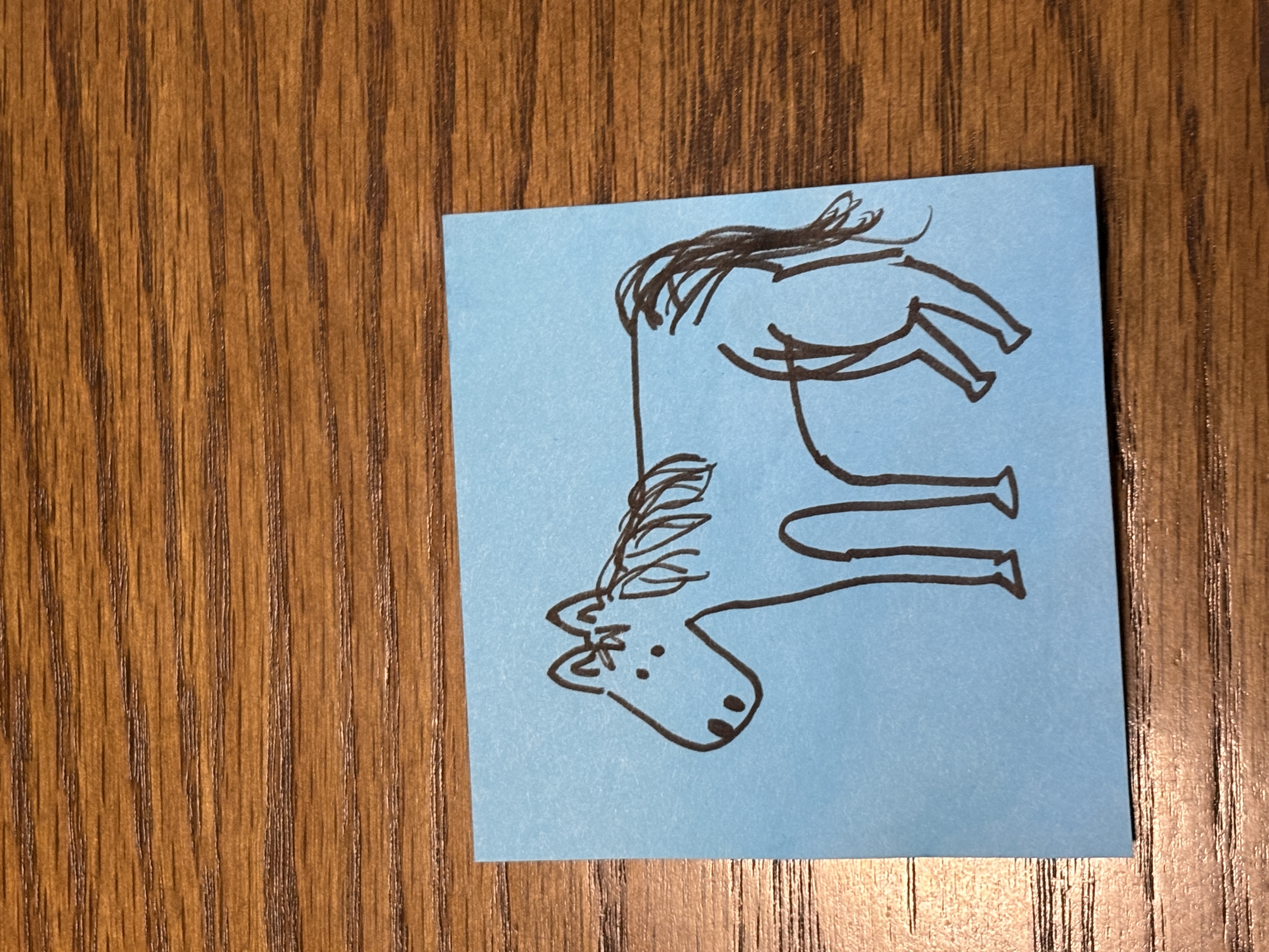 A simple, imperfect hand-drawn horse on a blue post-it note