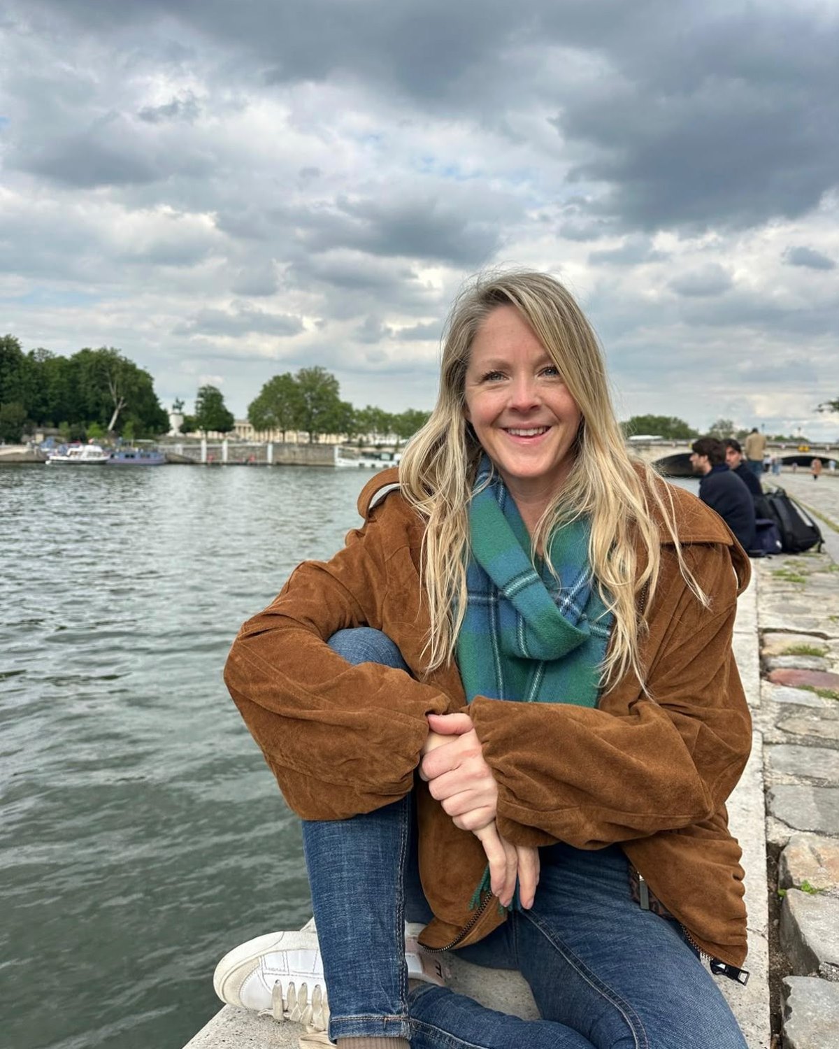 Kate Harlow smiling by the Seine in Paris