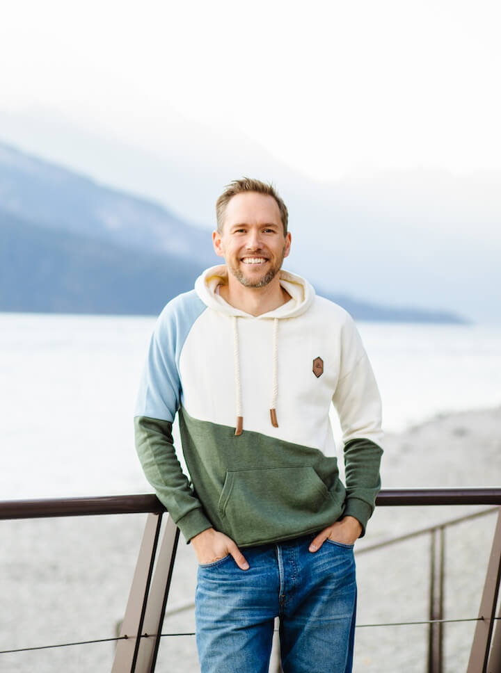 JD standing in front of a lake in a nice hoodie