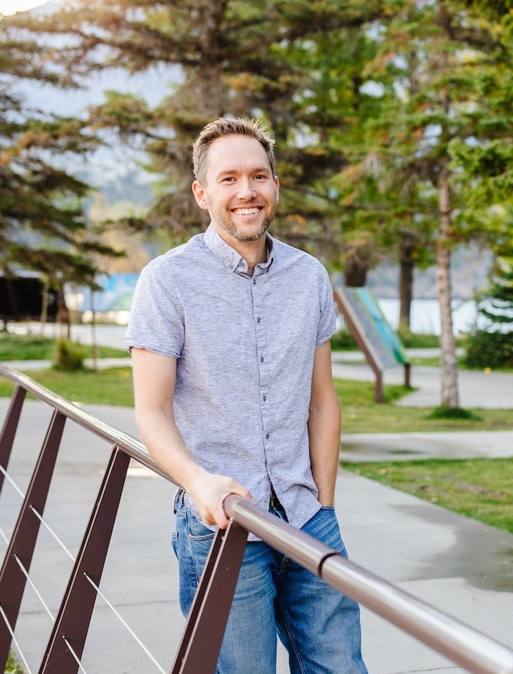 picture of JD in grey shirt standing by railing