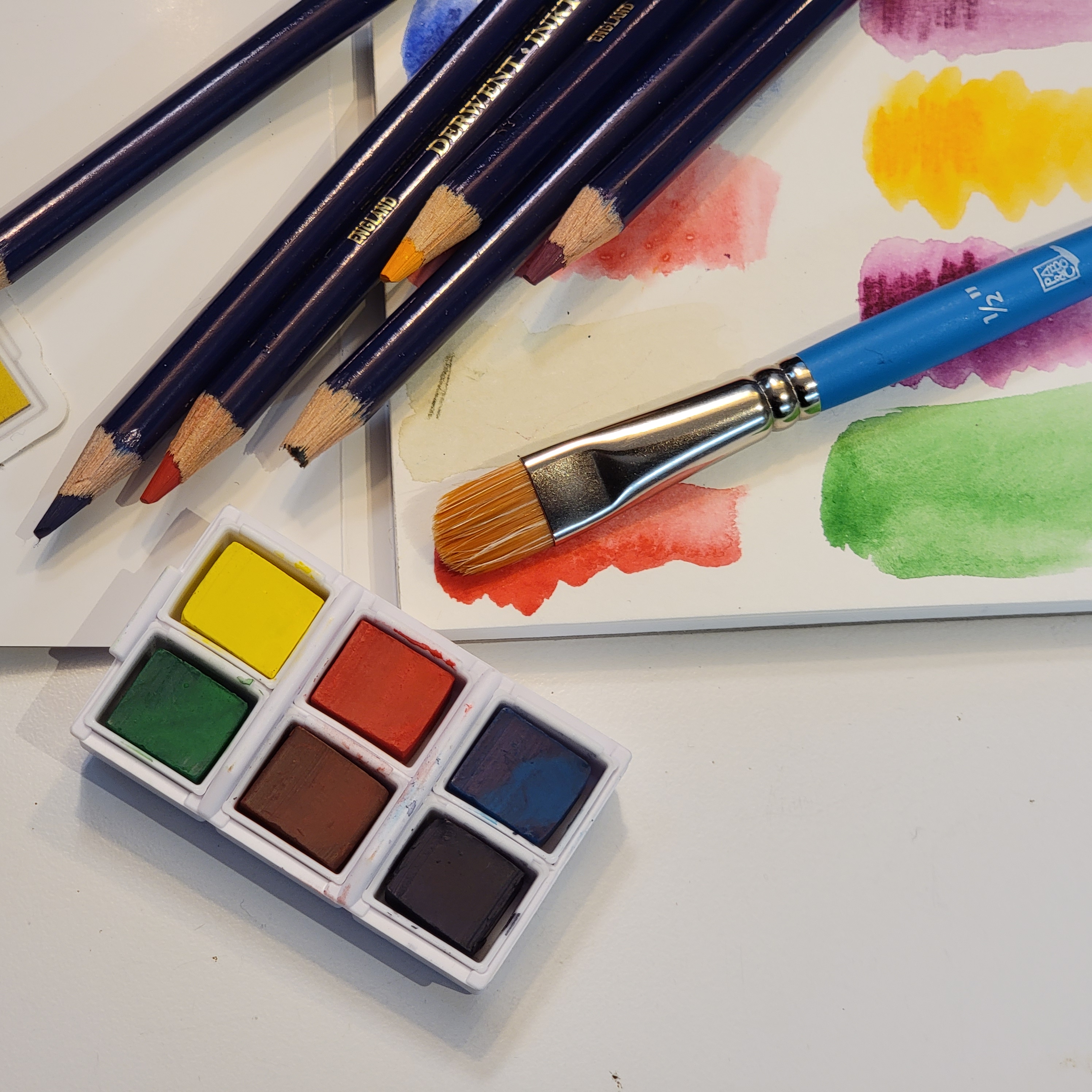 Palette d'aquarelle, pinceaux et nuancier de couleurs