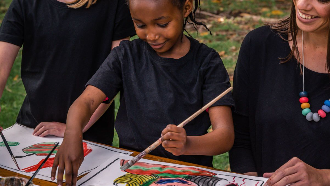 Child being taught art outdoors at home