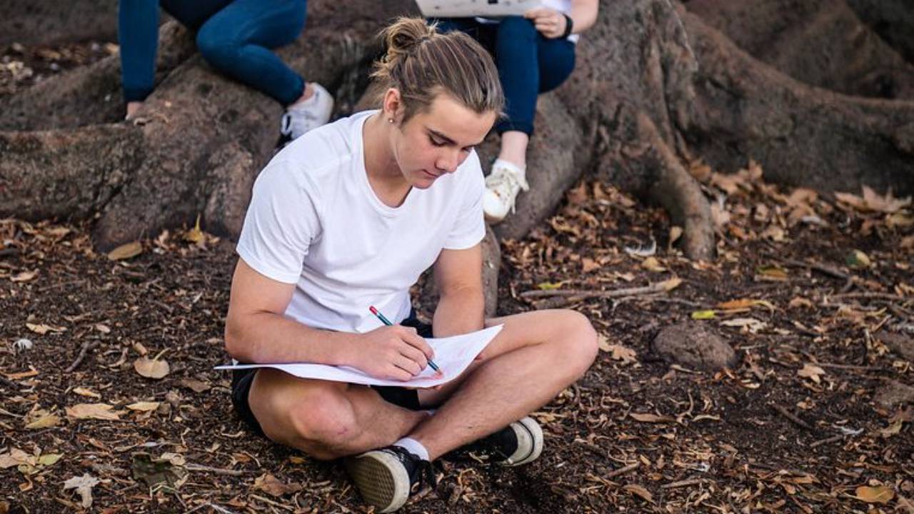 teen outdoors drawing an artwork