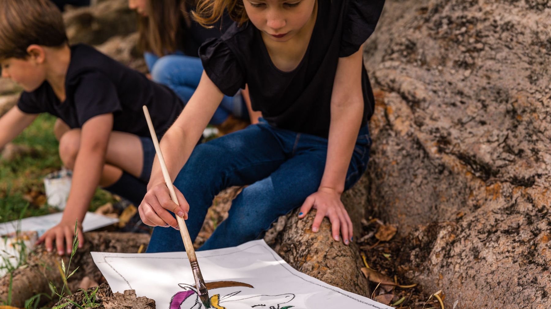 Girl painting artwork outdoors as part of her Artventure online art lessons