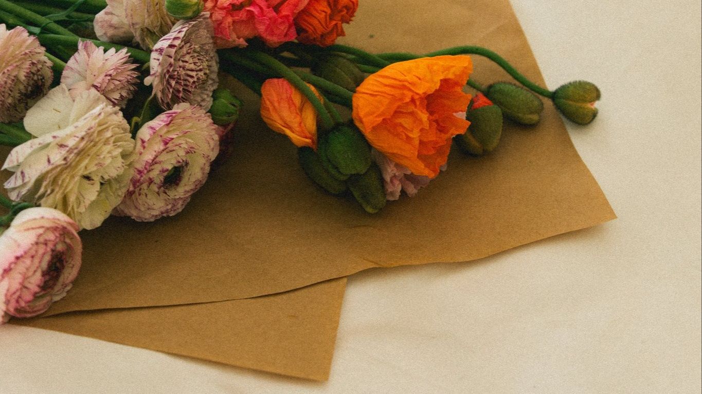 Vibrant spring flowers wrapped in kraft paper arrangement