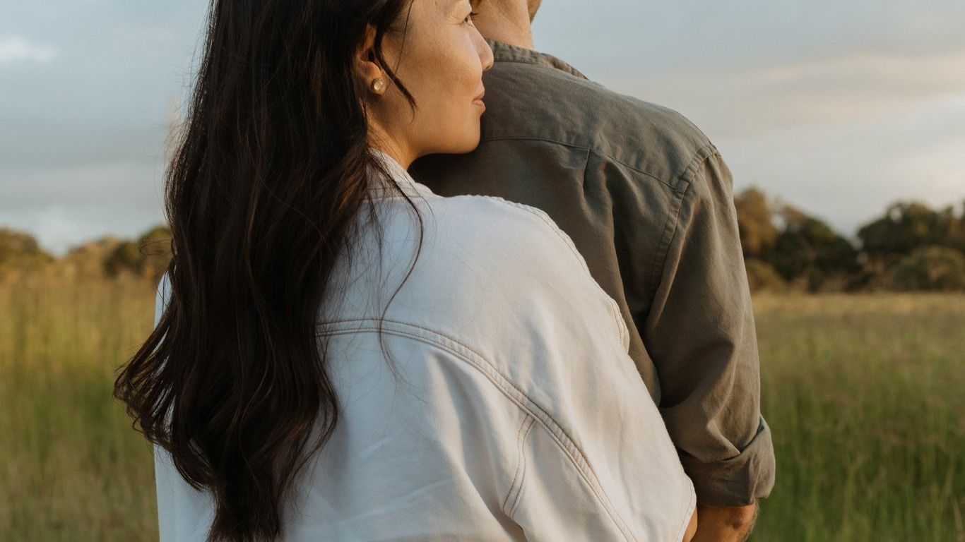 Couple embracing in golden hour countryside field