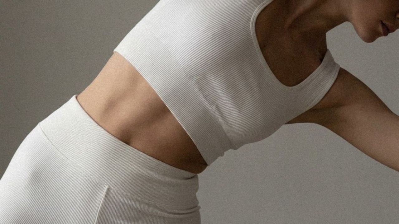 Woman in white ribbed crop top and high-waisted shorts