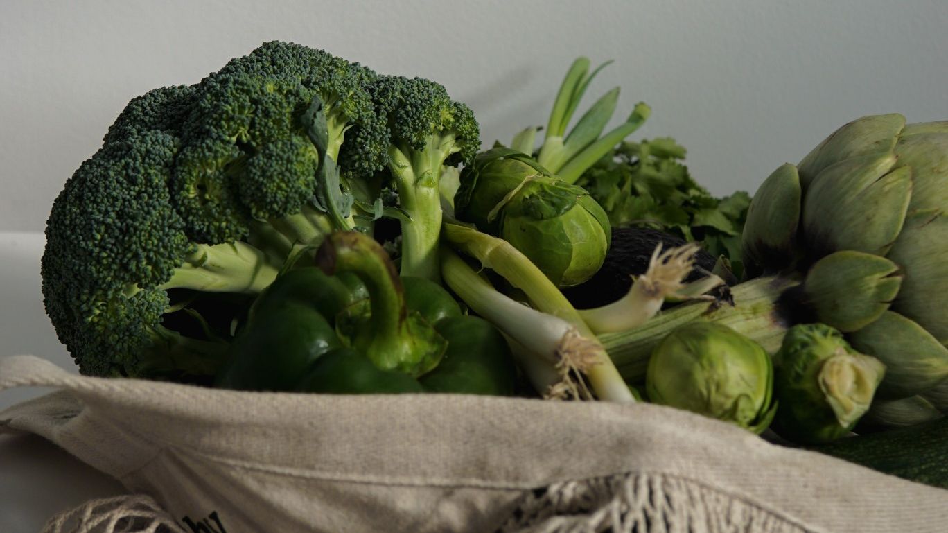 Fresh green vegetables in sustainable mesh produce bag