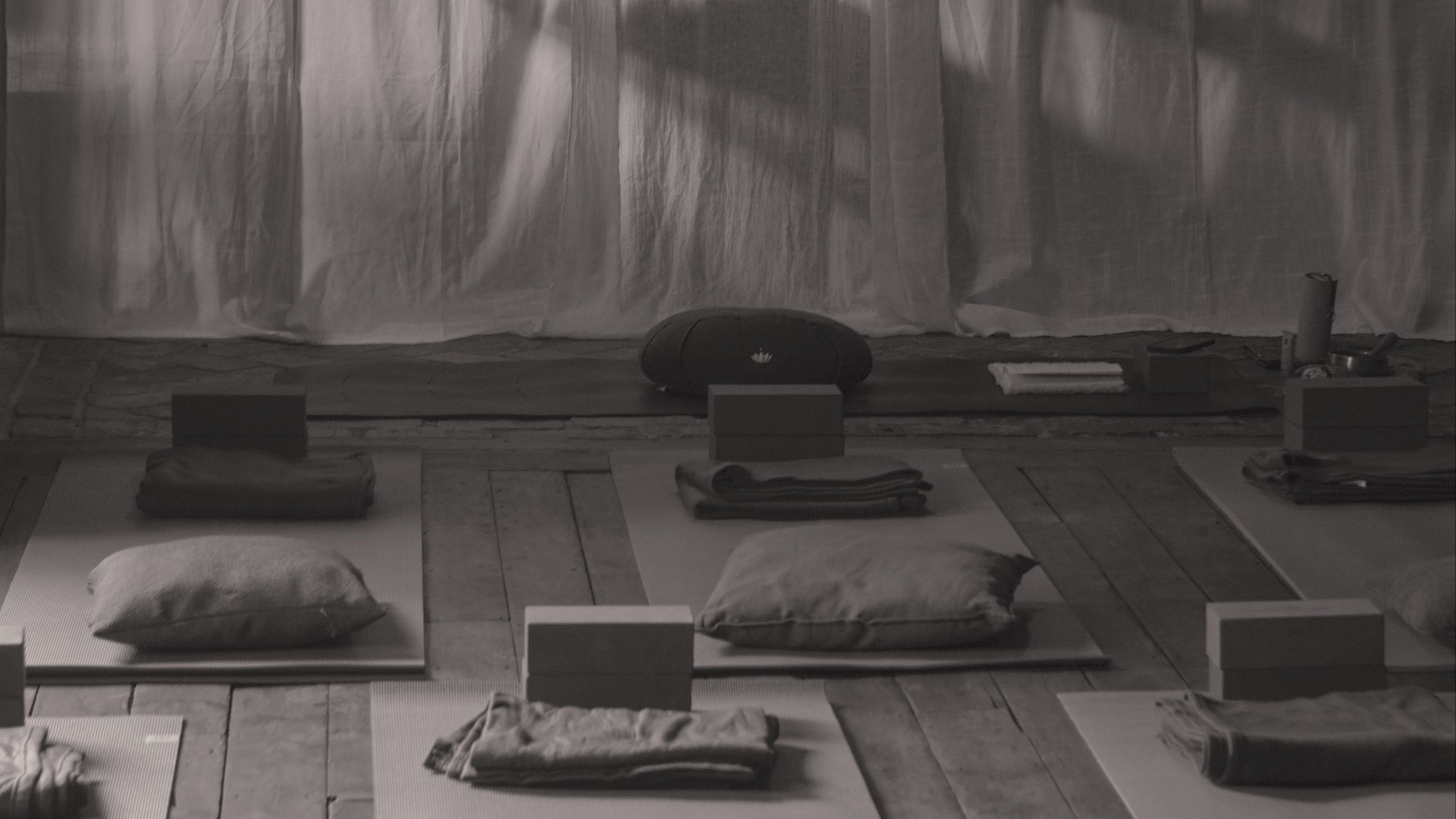Minimalist meditation space with cushions and flowing curtains