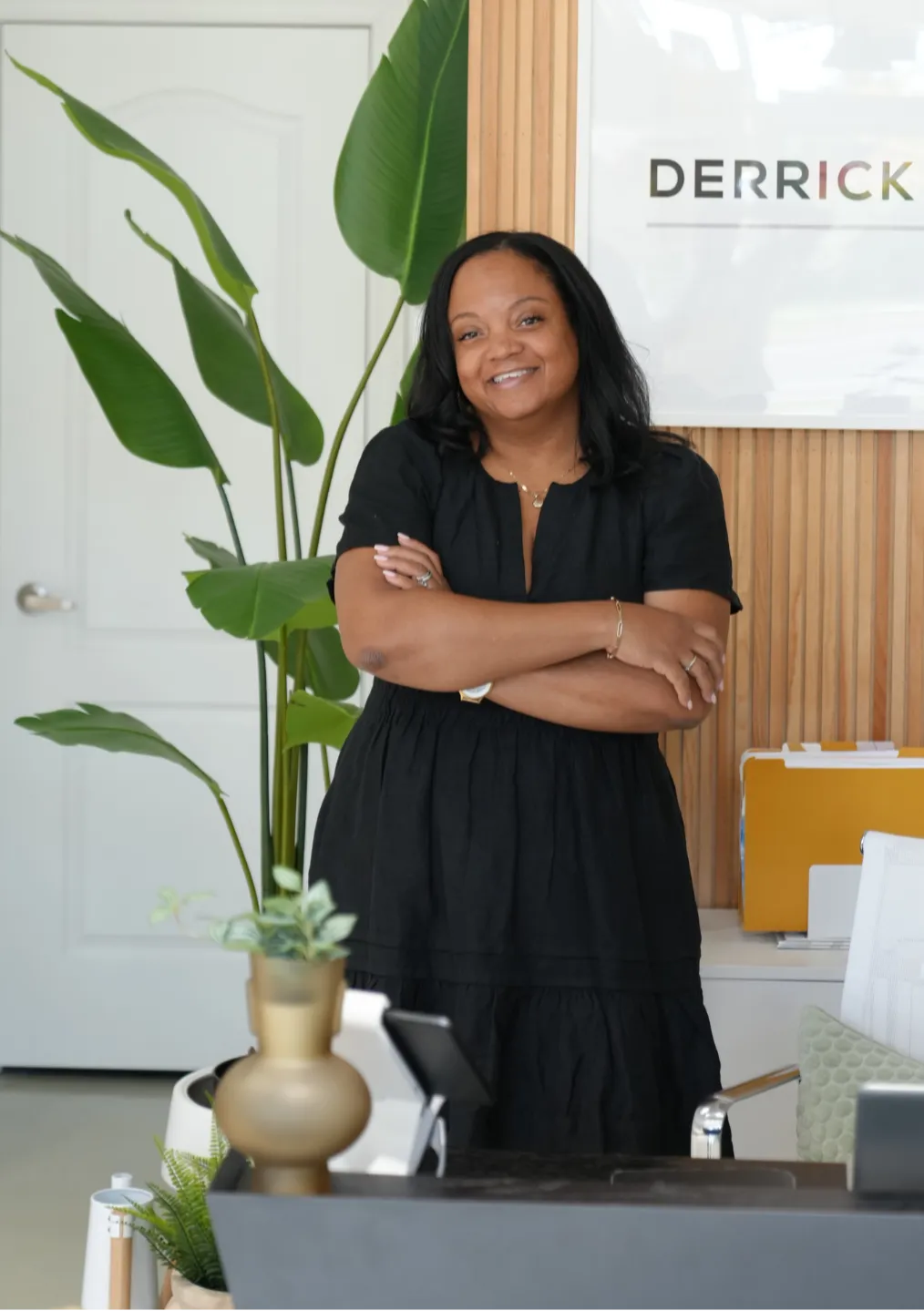 Chiriga Derrick standing confidently in her office, representing her mission to empower entrepreneurs to thrive in business and life.