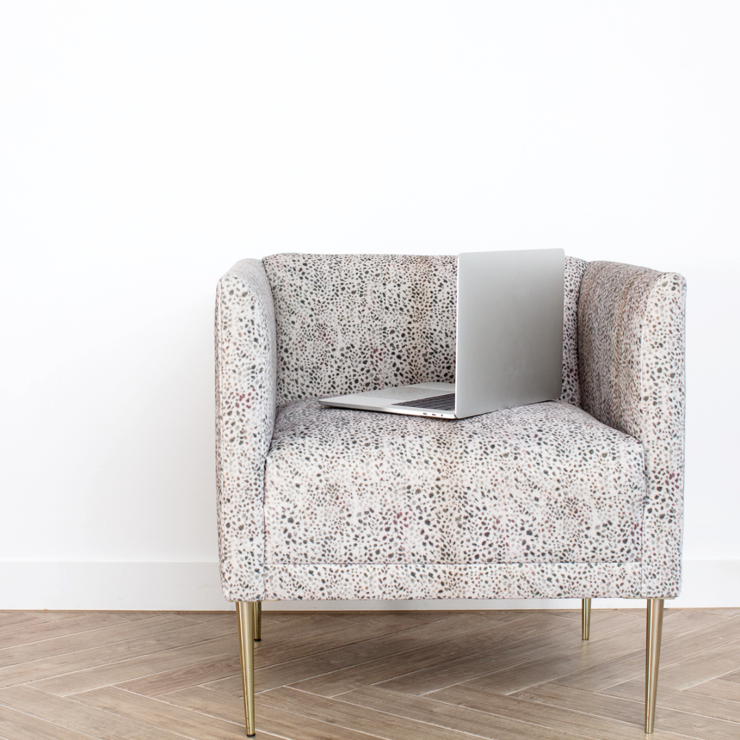 Modern patterned chair with a laptop, symbolizing strategic thinking and brand alignment in a stylish workspace.