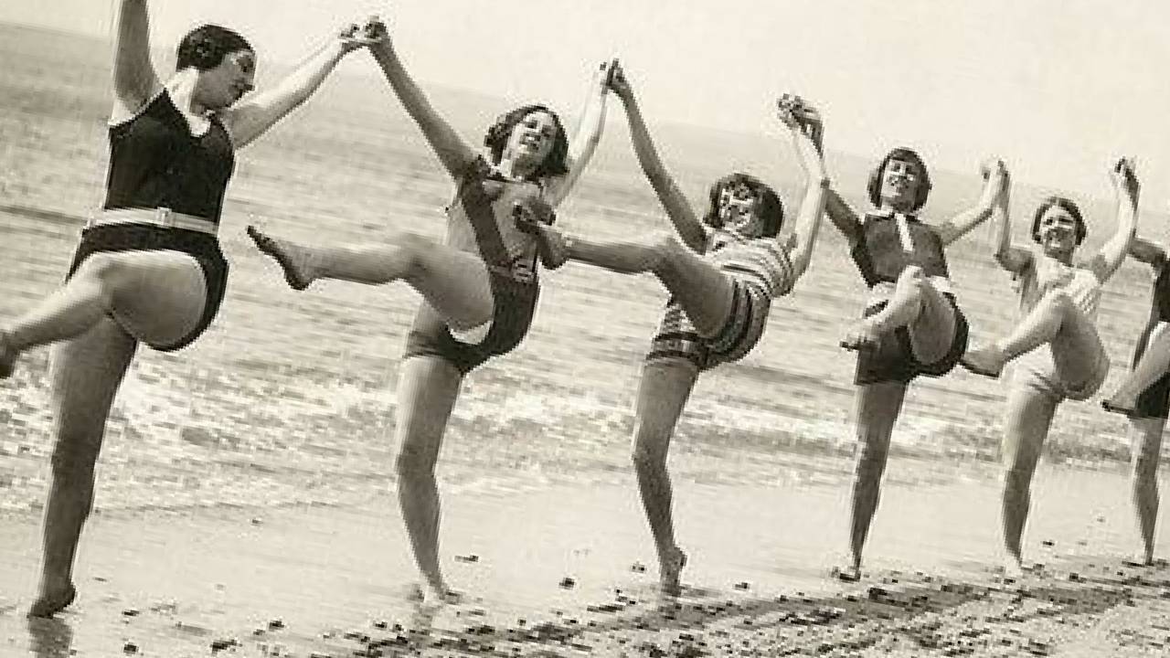 Vrouwen dansen samen, gearmd, op het strand