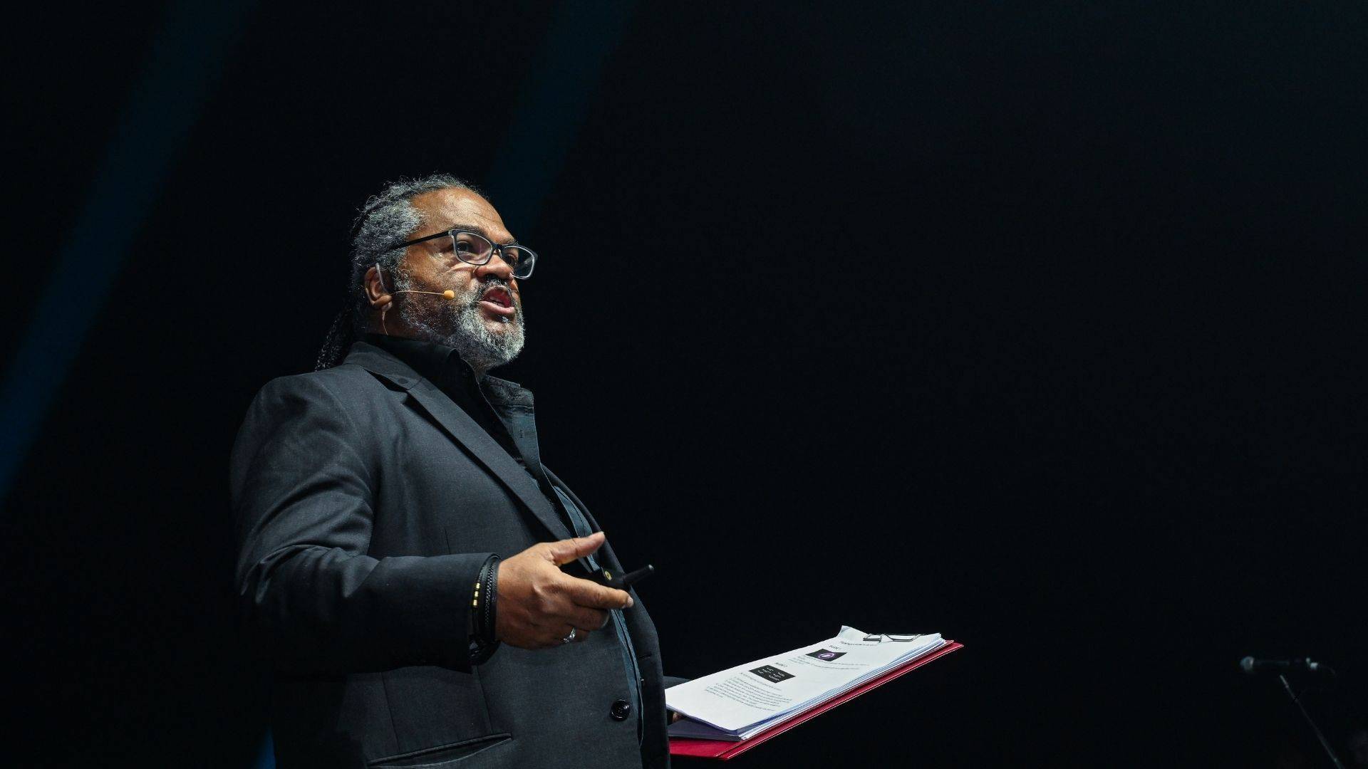 Dave Crane speaking on stage during a keynote presentation at a corporate event.