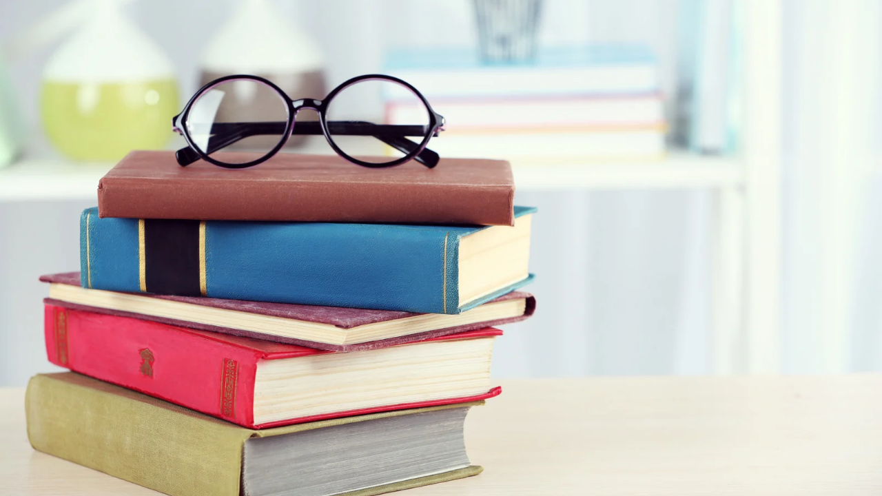 stack of books with glasses on top