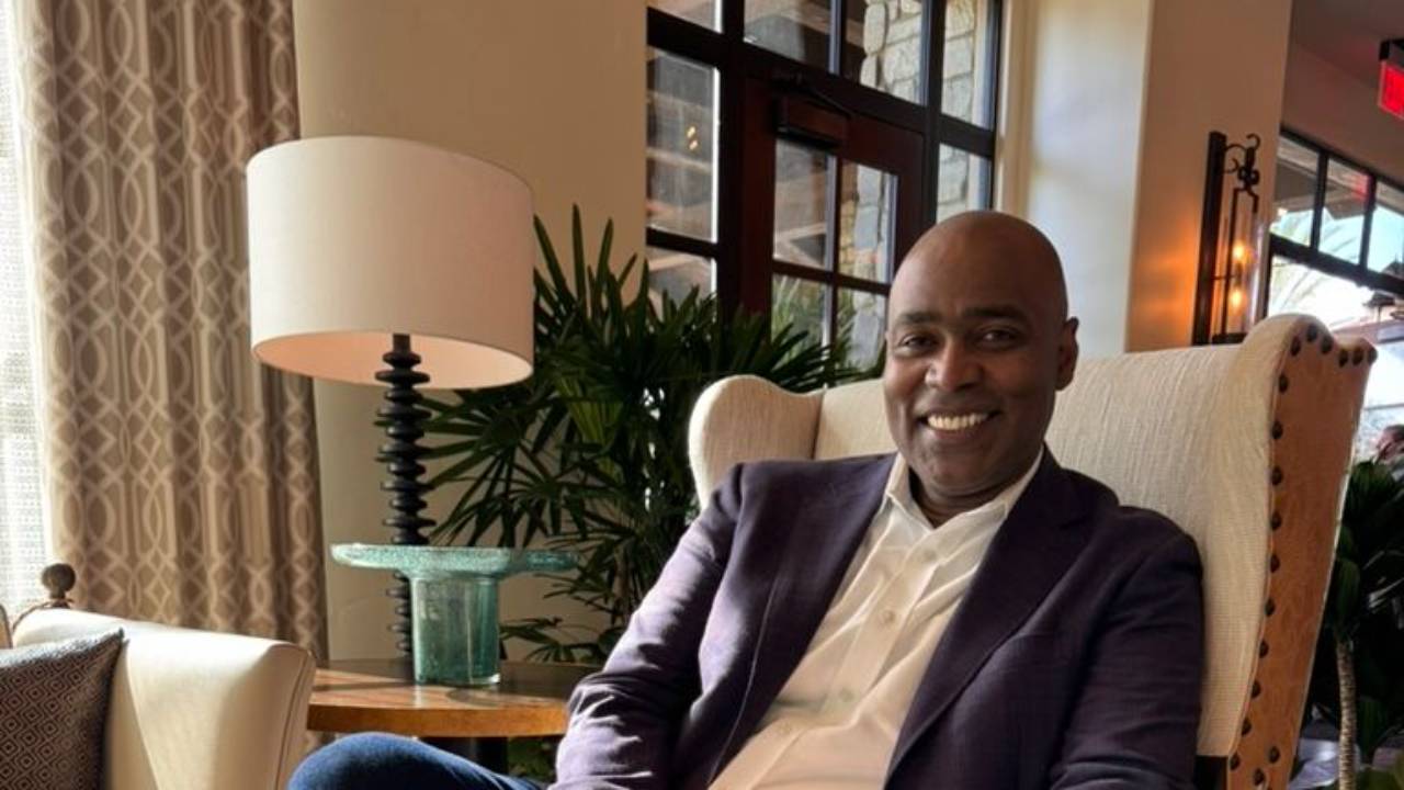 Ivan smiling from an armchair
