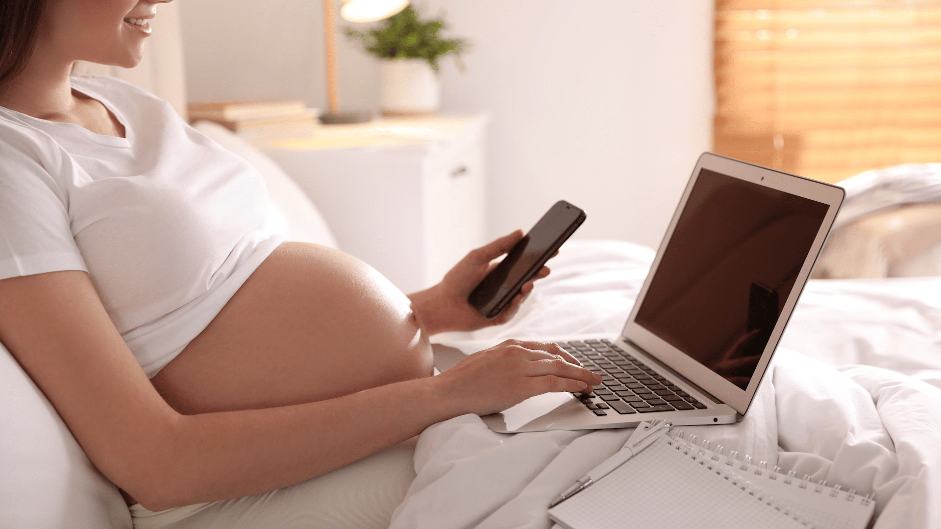 Pregnant mother on laptop and phone 