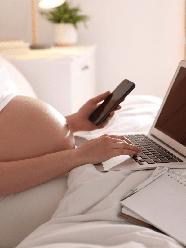 Pregnant Woman Working Bed Home Closeup Maternity Leave Pregnant woman working on bed at home - closeup