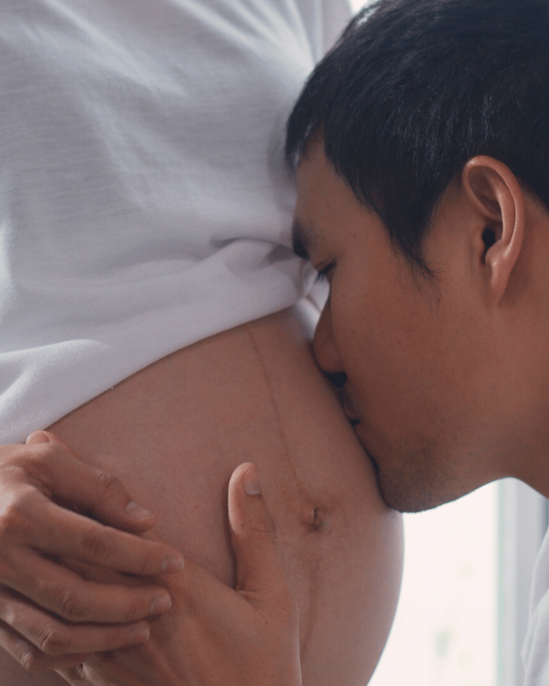 Young Asian Pregnant Couple Man Kissing His Wife Belly