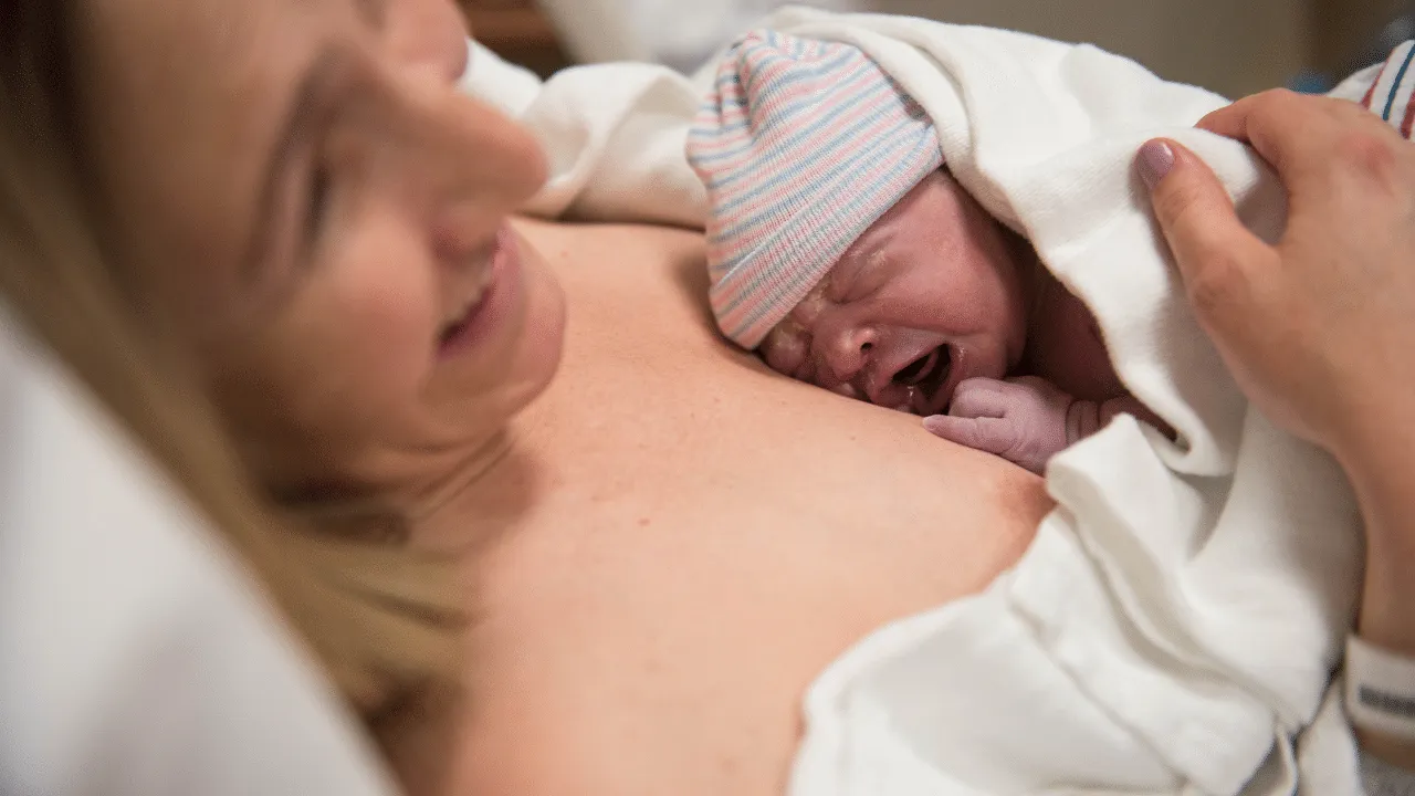 Newborn baby with happy mother skin-to-skin