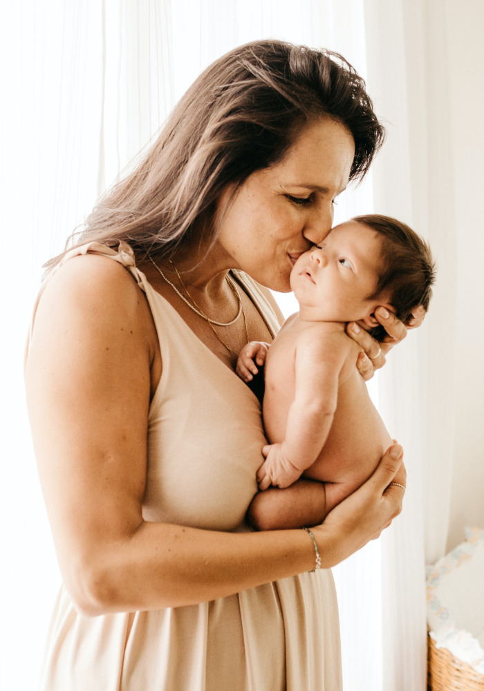 Mum kissing newborn baby