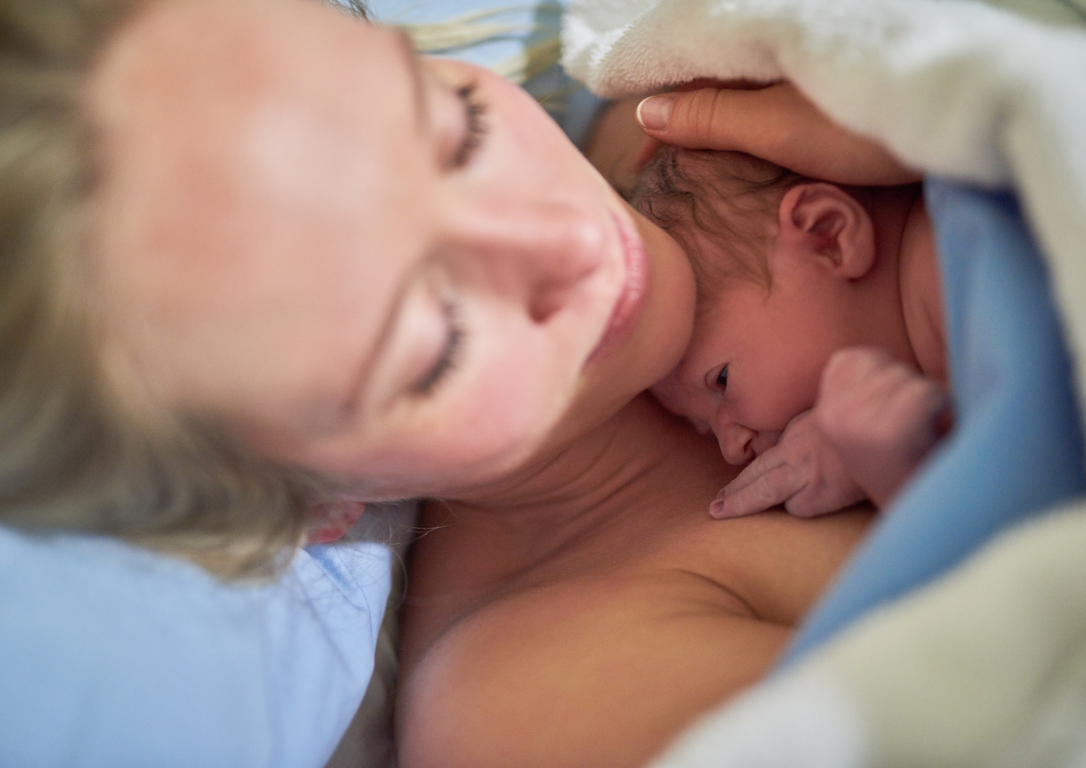 BIrthing mother with newborn baby