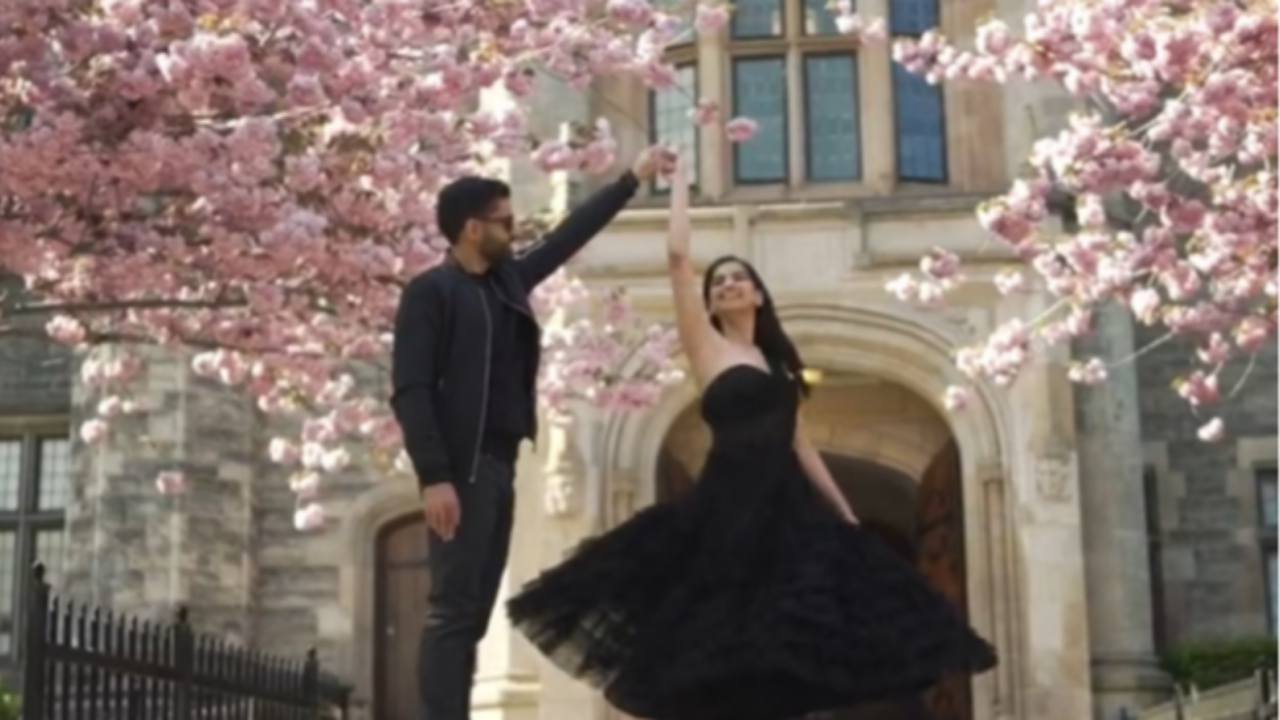 Clean still from a Happy Soul Films engagement film: couple dancing beneath spring blossoms.