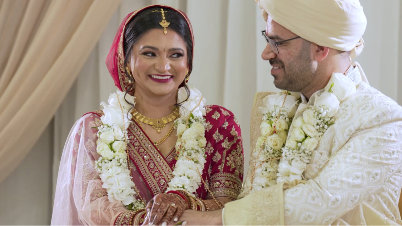 Clean still from a Happy Soul Films South Asian wedding film: newlywed couple smiling together in traditional wedding attire.