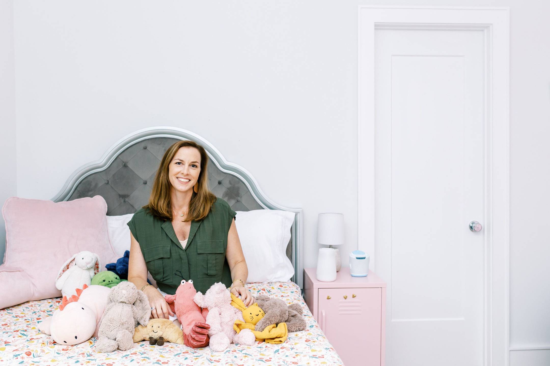 Jessica Berk sitting with stuffed animals in a child's bedroom
