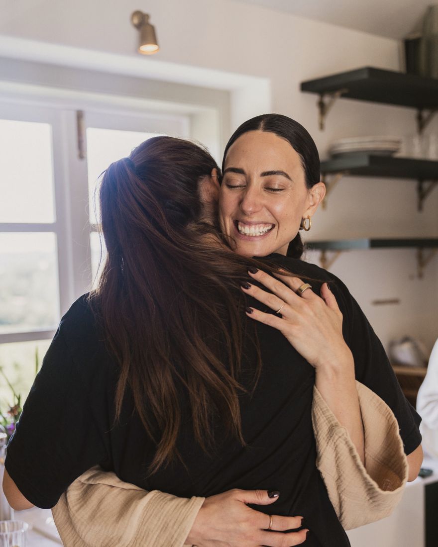 Georgiana holding one of the women close, eyes closed