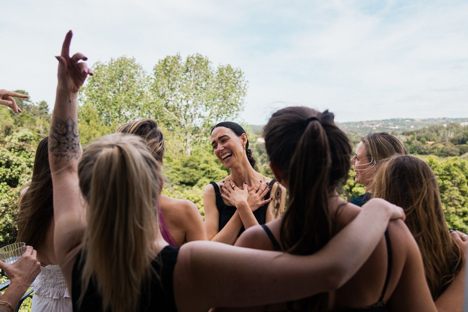 The women of the retreat arm in arm, one hand raised