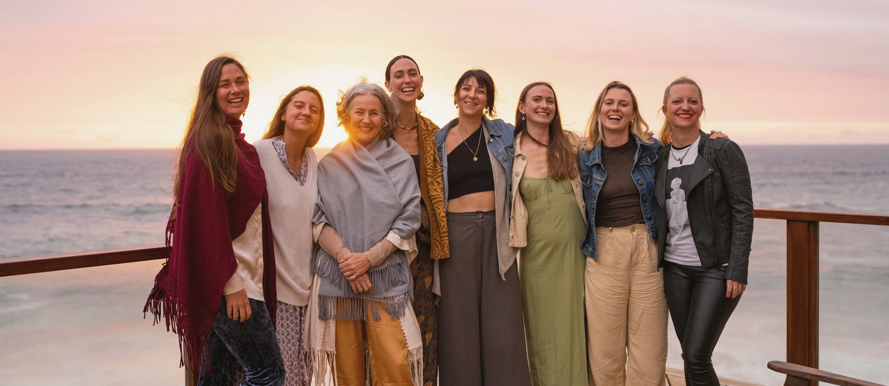 The women of the retreat together on the deck at sunset