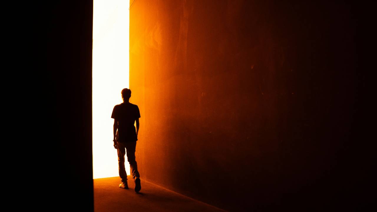 Person standing in front of an open door.