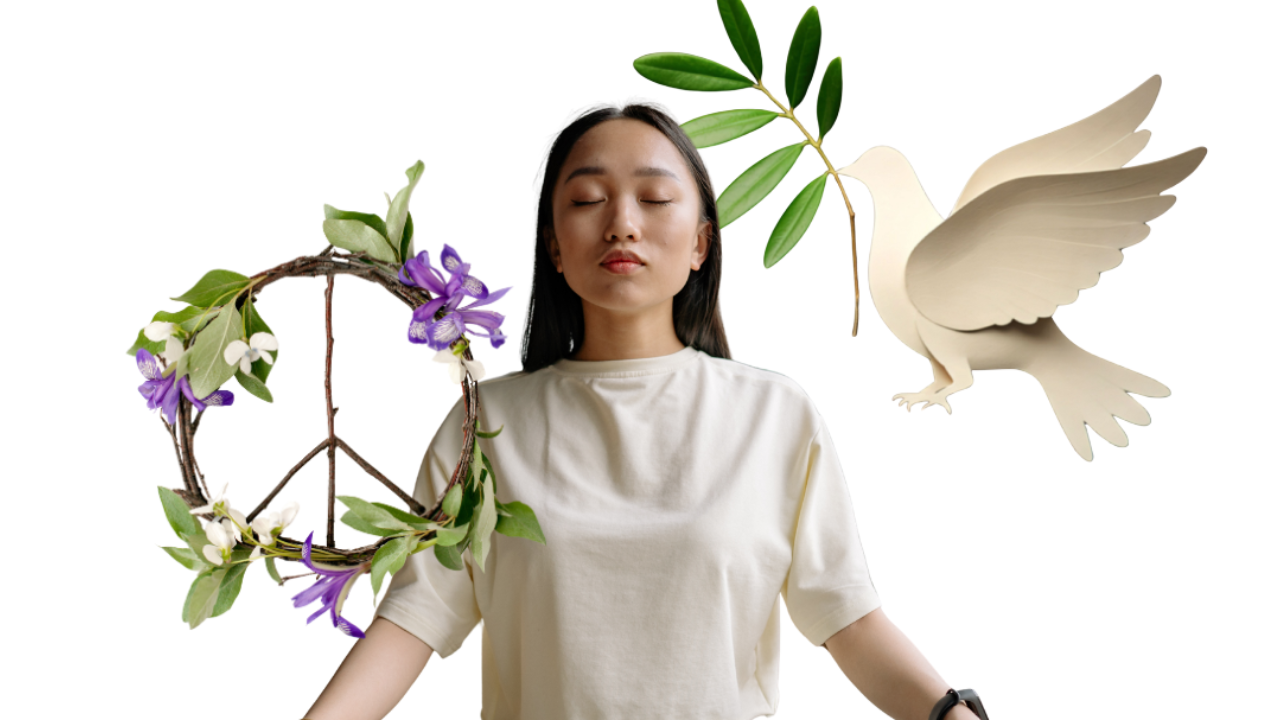 Woman meditating with a paper dove holding an olive branch over one shoulder and a peace sign made from a branch with purple flowers.