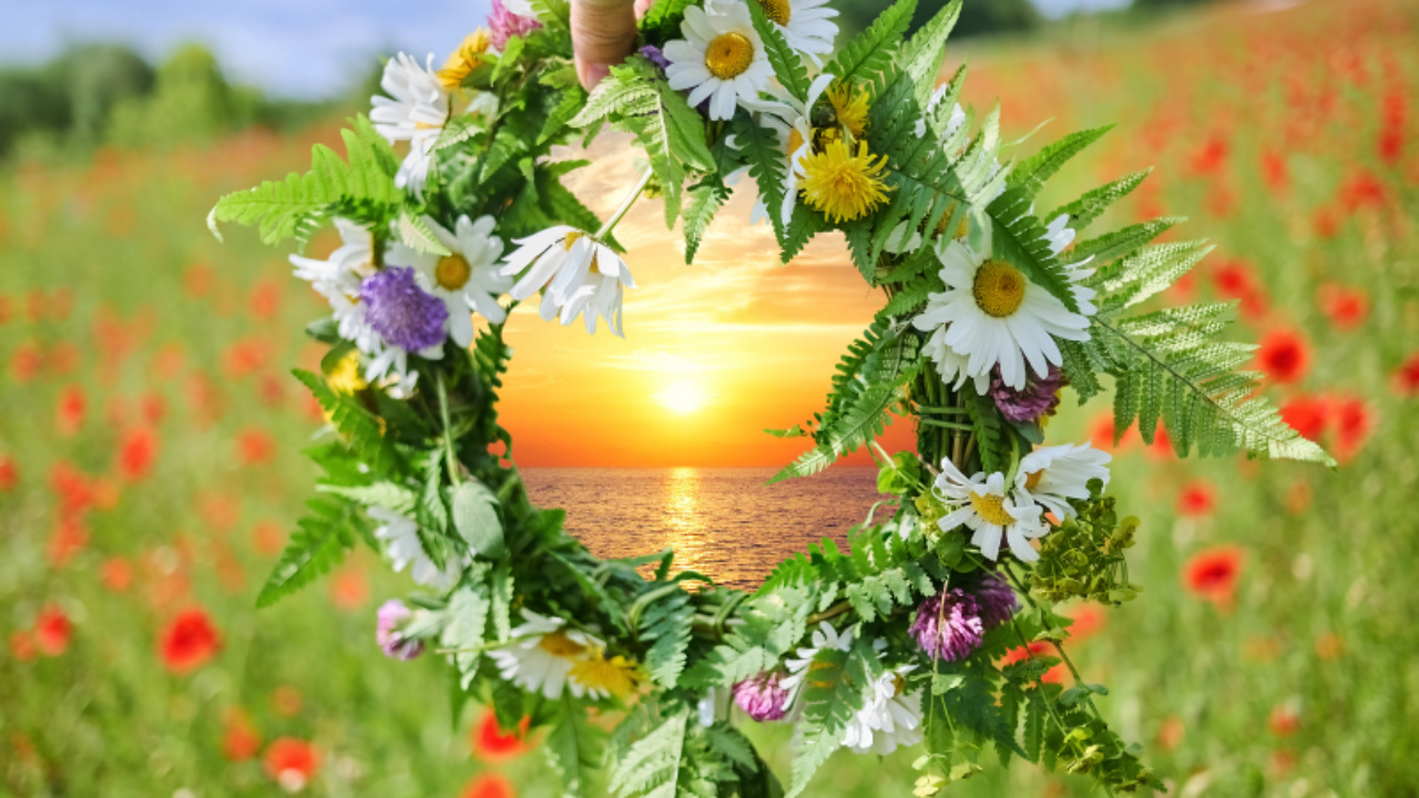 Summer Solstice wreath in a field framing a sunrise over the water.