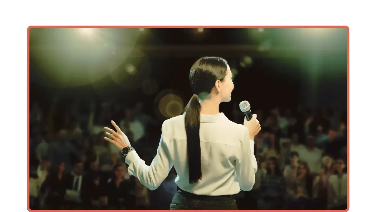 Mujer habla a una audiencia con micrófono
