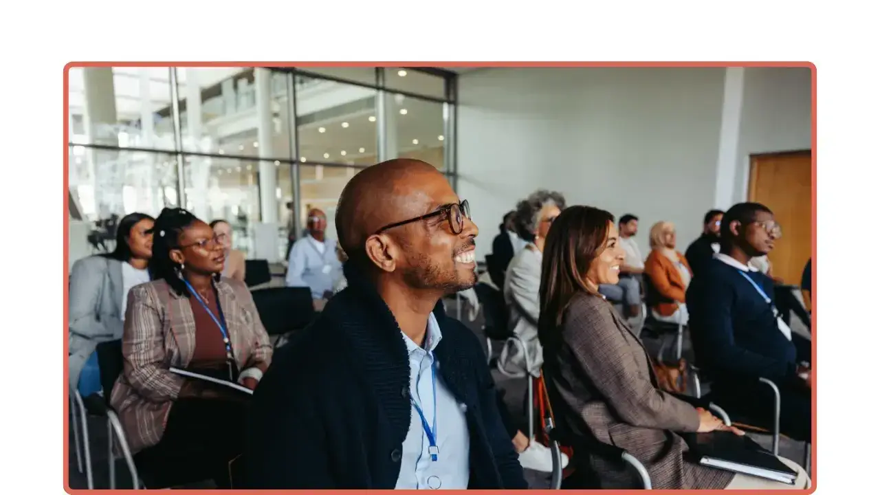 Grupo de profesionales escuchando con atención durante una capacitación o seminario.