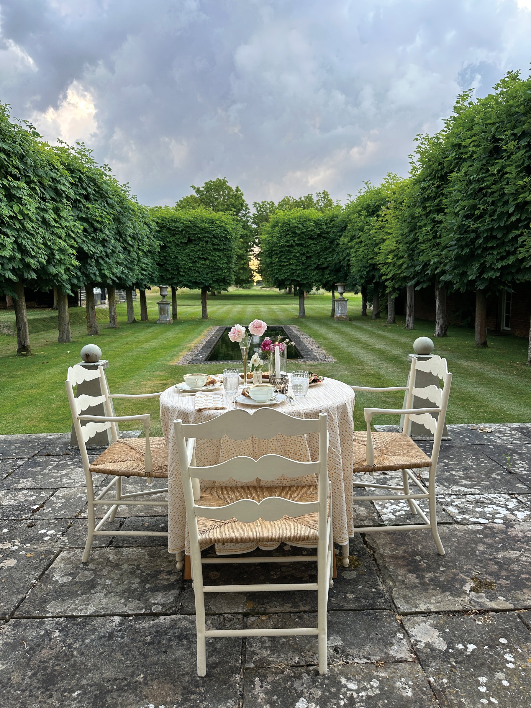 A table set for dinner in an English garden allee