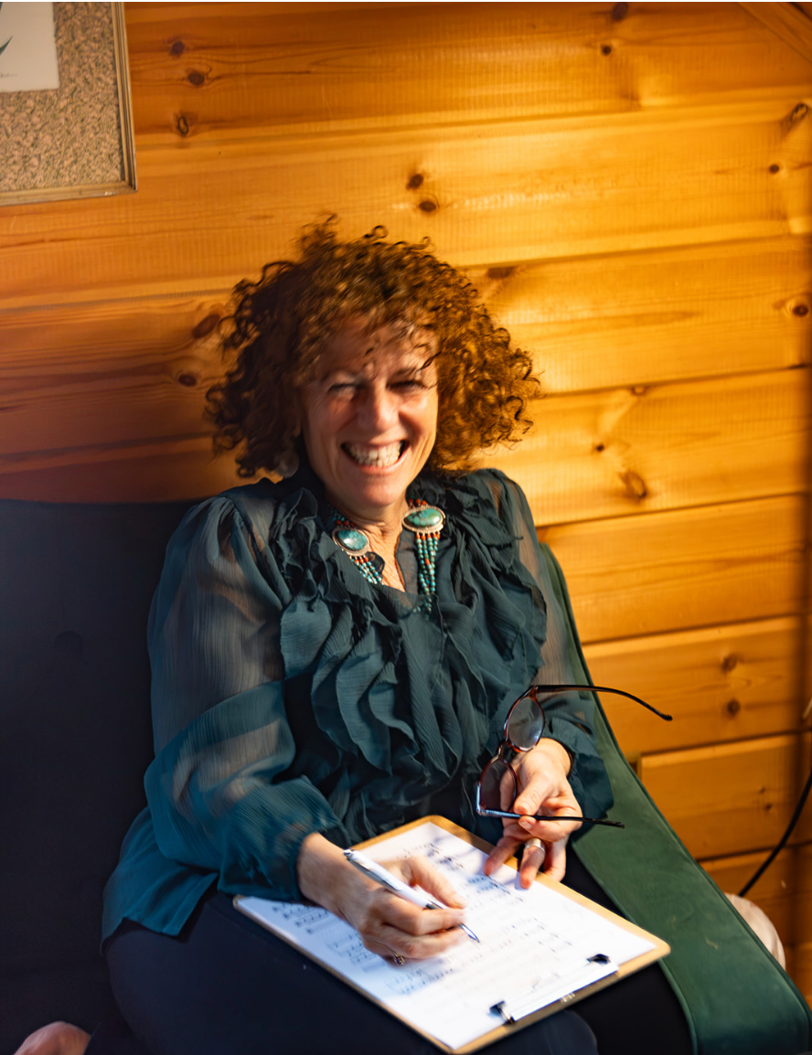 Lisa Smartt smiling while writing in a notebook