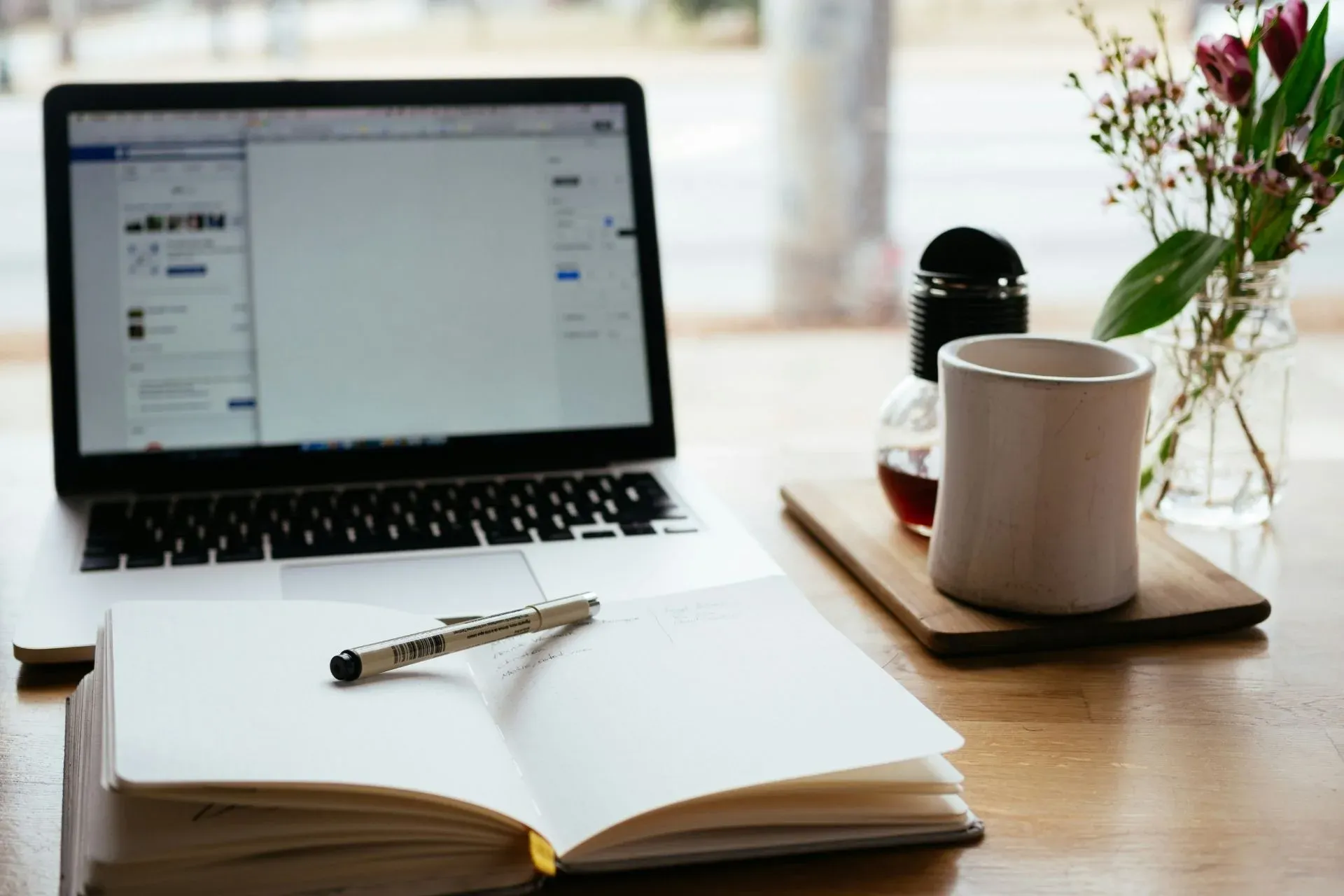 A peaceful home workspace with an open notebook and laptop, representing the self-paced learning experience of the Mastering the MedLife Matrix course.