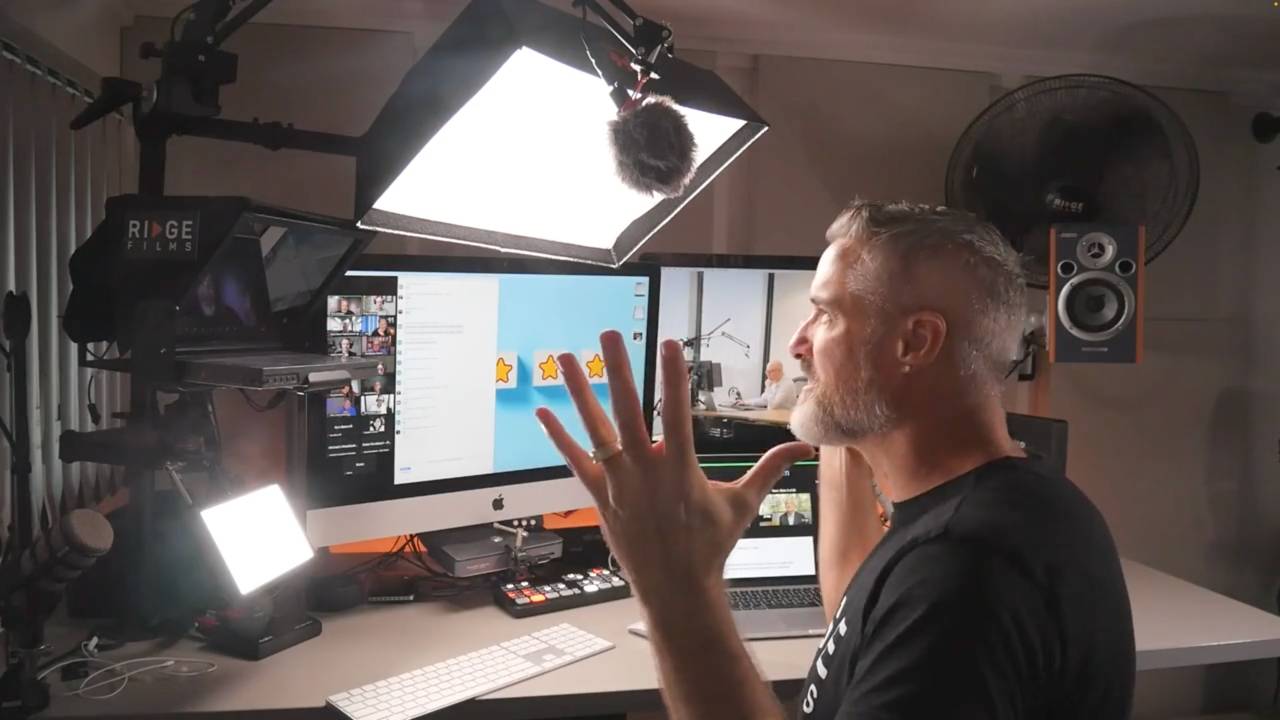 Chris Schwager gesturing at a Zoom coaching call on his iMac in the Ridge Films studio