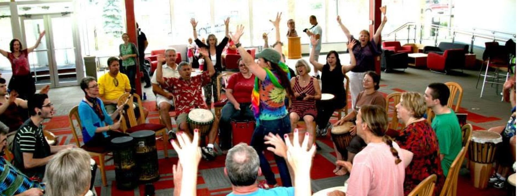 Participants practicing drum circle facilitation in a small group during the training