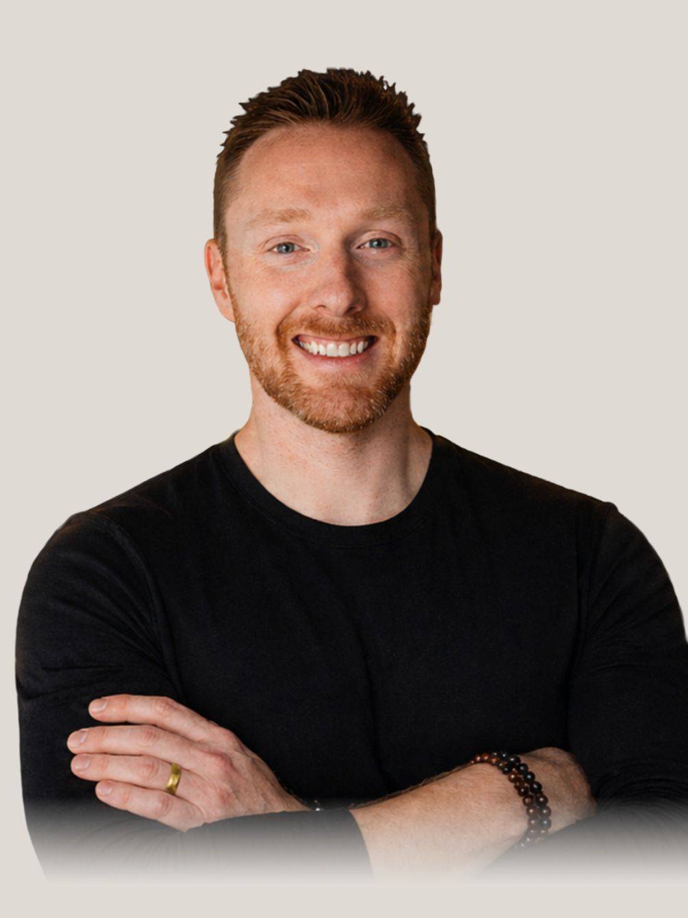 Anthony Price with arms crossed in a black long-sleeve top
