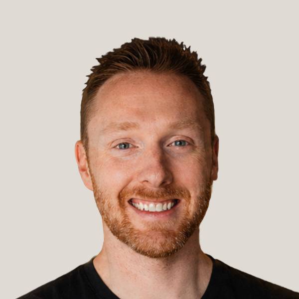 Anthony Price with arms crossed in a black long-sleeve top